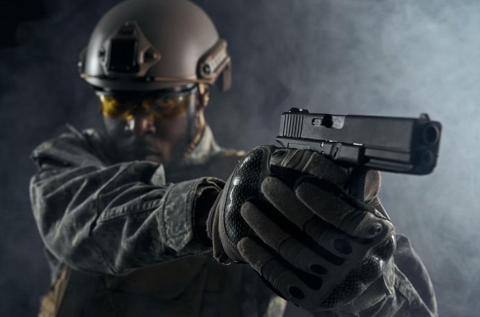 a black soldier in a helmet aiming a handgun