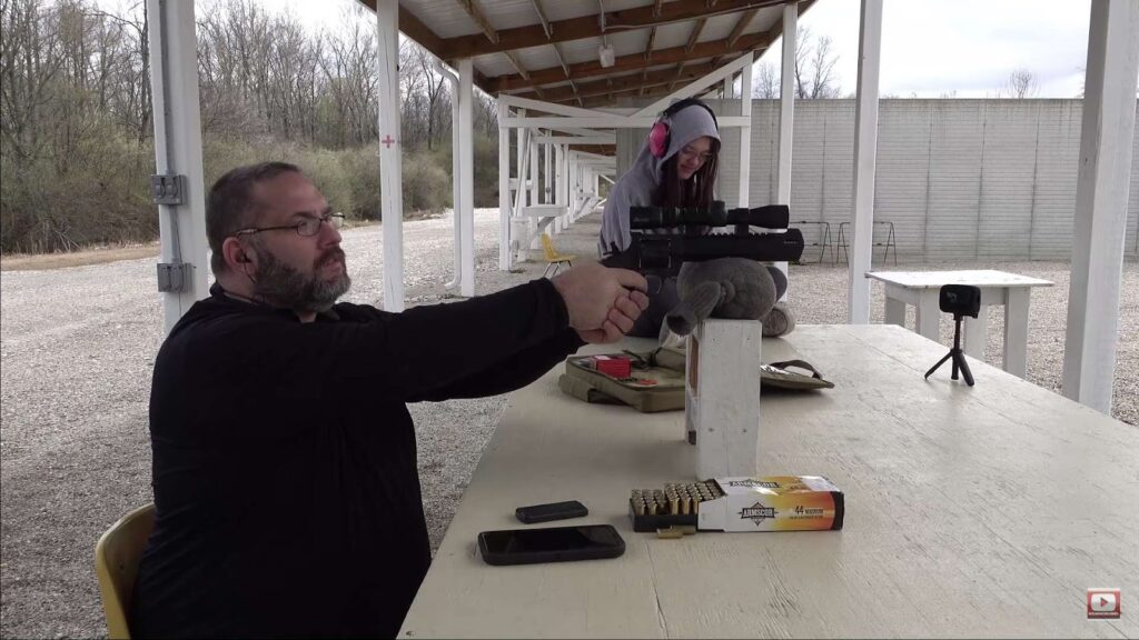 Man aiming a pistol using a scope